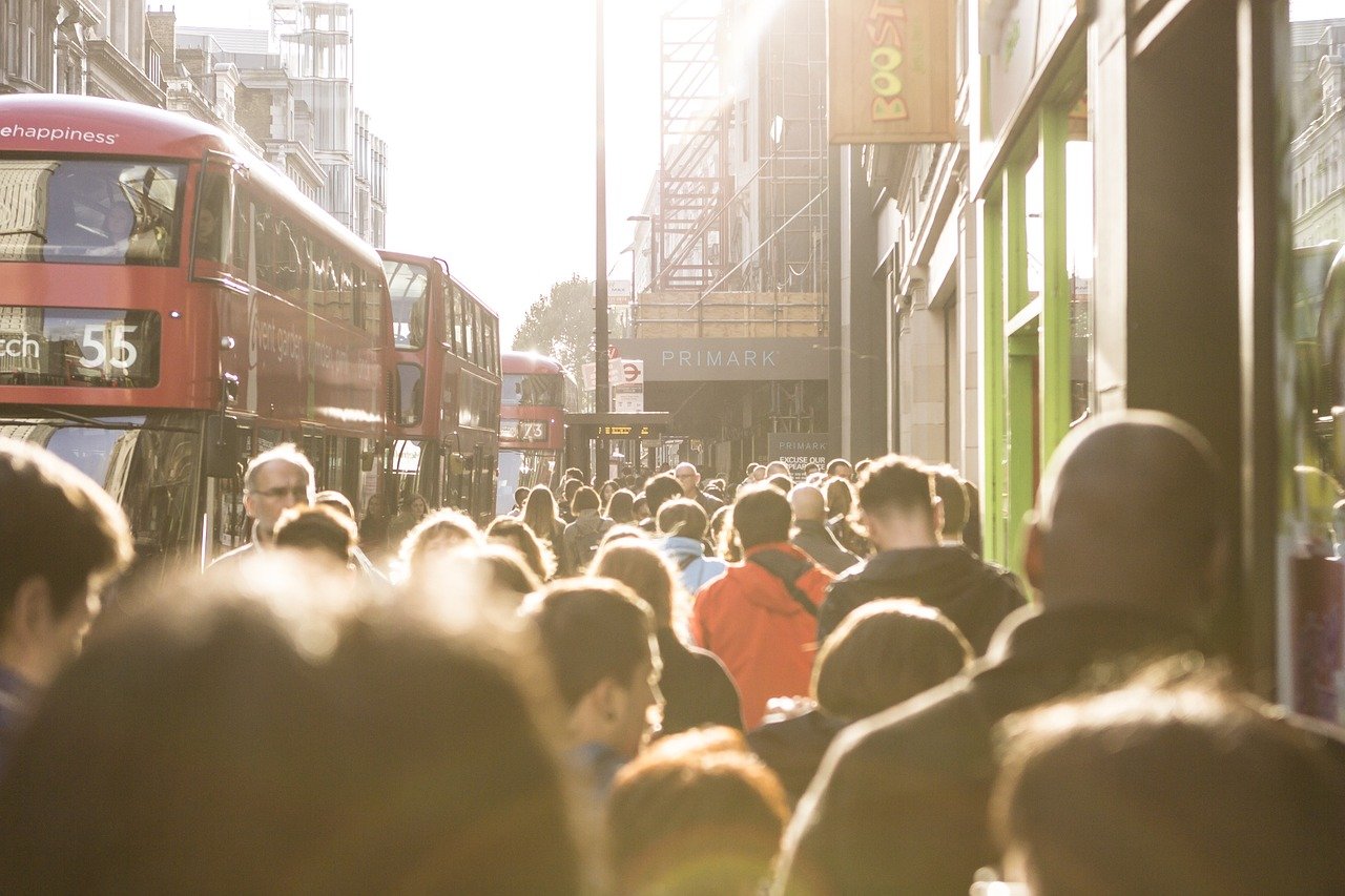 Crowded London street with double-decker buses and pedestrians, reflecting the impact of the UK immigration proposals for 2025 on daily life.