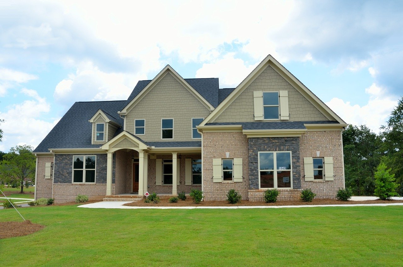 Two people shaking hands in front of a newly purchased house, symbolizing successful property transactions with Purpose Codes for CHAPS Payments.