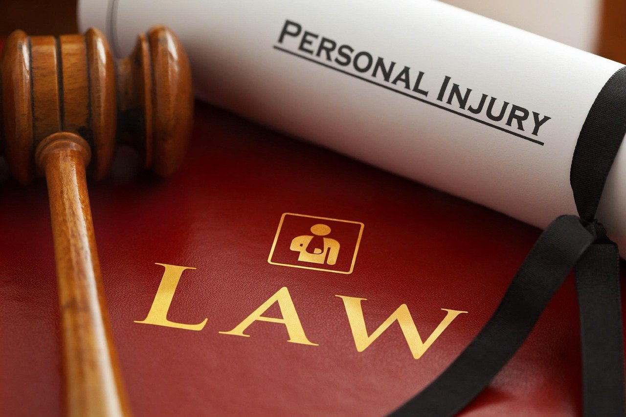 Personal injury claim legal process illustrated by a law book, gavel, and injury claim document.