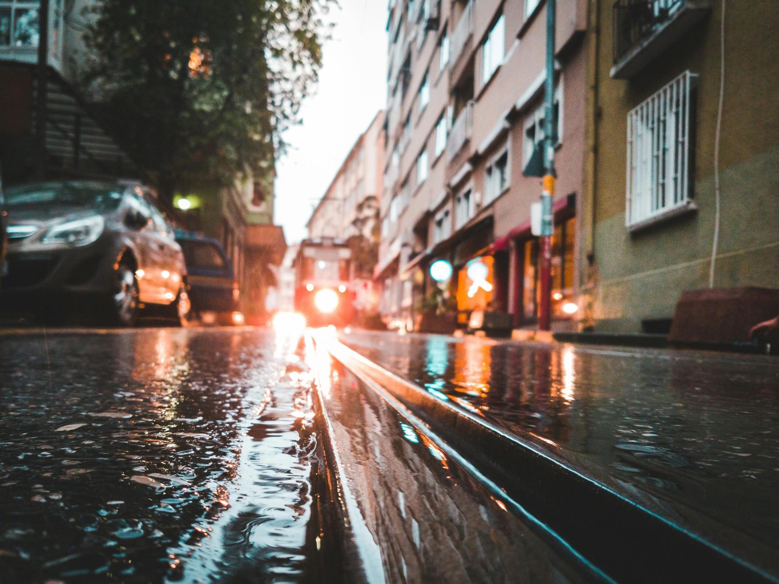 Wet city street with standing water after heavy rain, illustrating potential Escape of Water Injury risks.