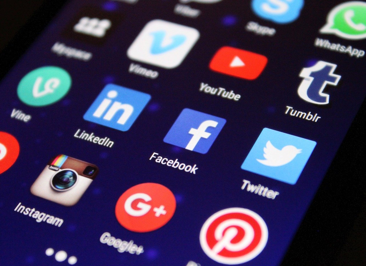 Smartphone screen displaying social media app icons including Facebook, Twitter, LinkedIn, and Instagram.